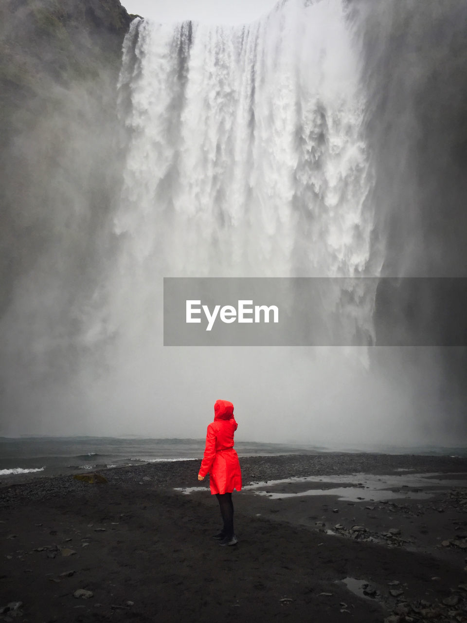 Woman standing in front of a waterfall