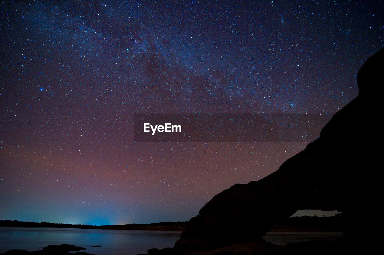 Silhouette mountain against sky at night