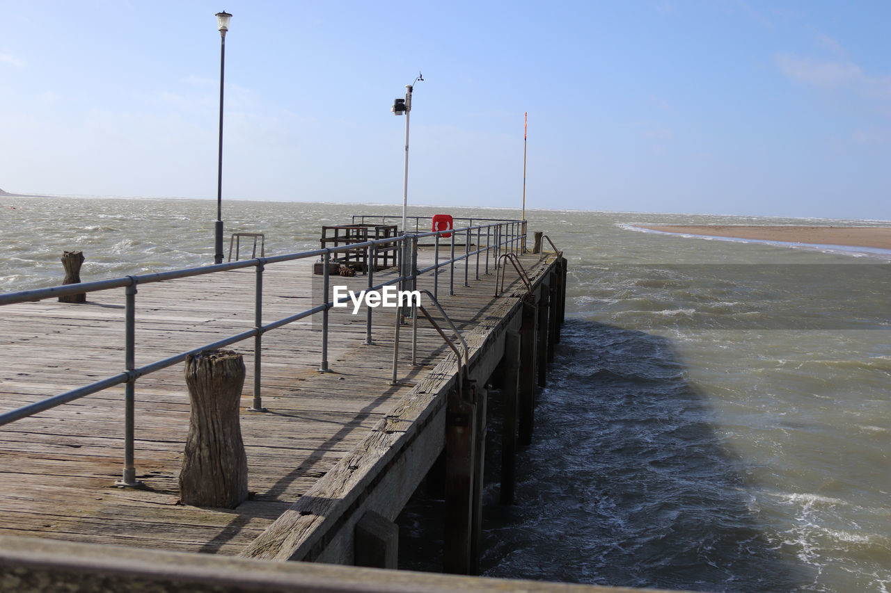 PIER ON SEA SHORE AGAINST SKY