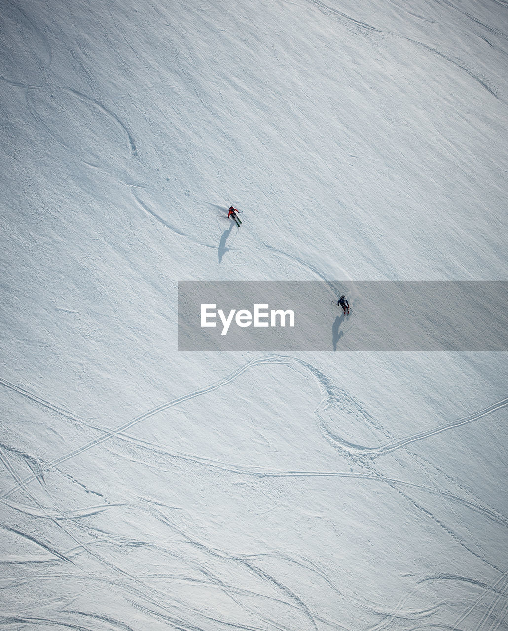 Two men skiing on snow in iceland from overhead angle