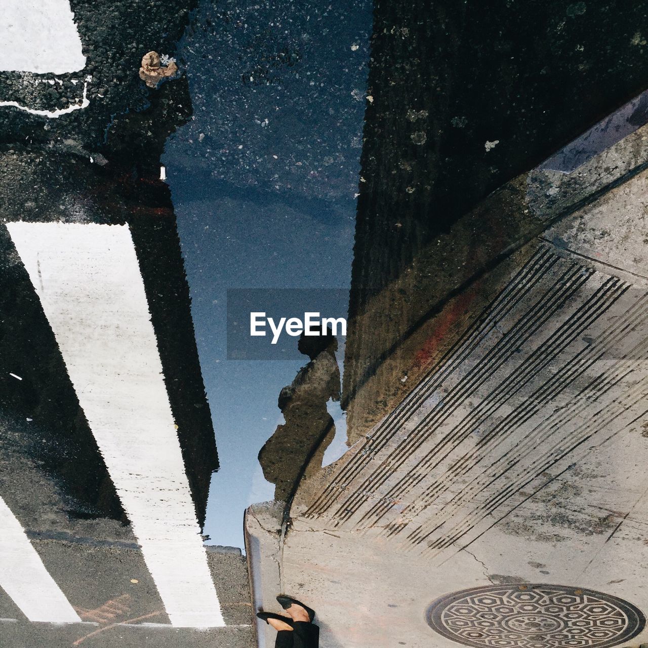 Reflection of woman on puddle