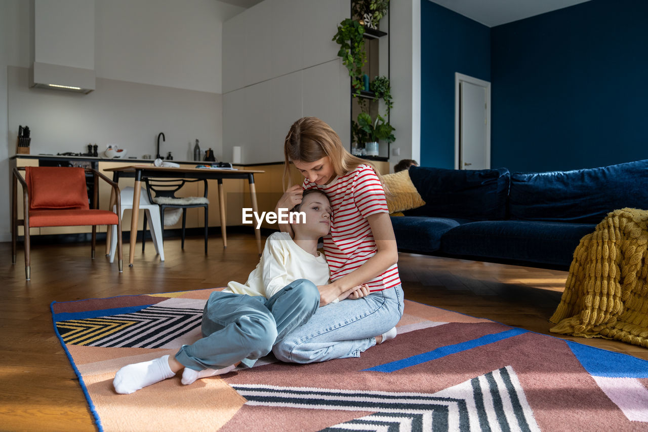 portrait of woman using laptop while sitting on sofa at home