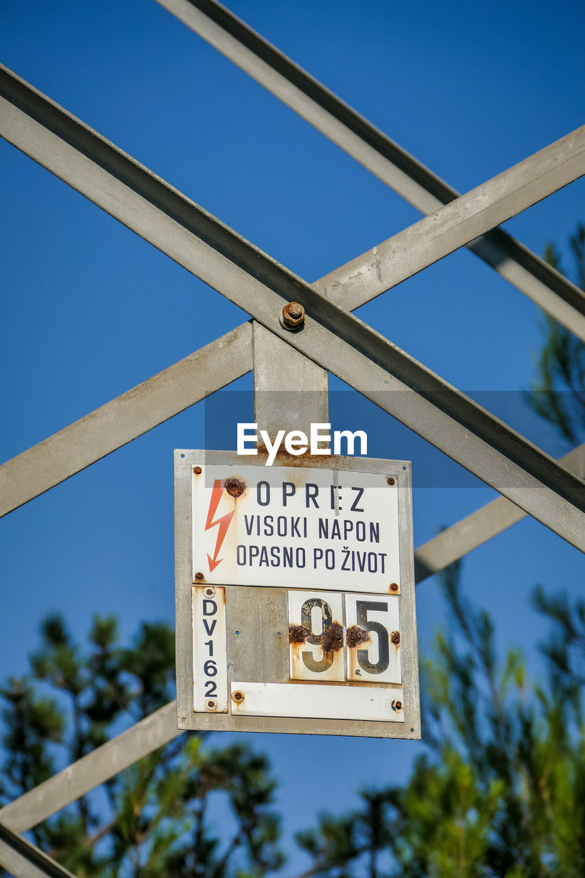 LOW ANGLE VIEW OF INFORMATION SIGN AGAINST SKY