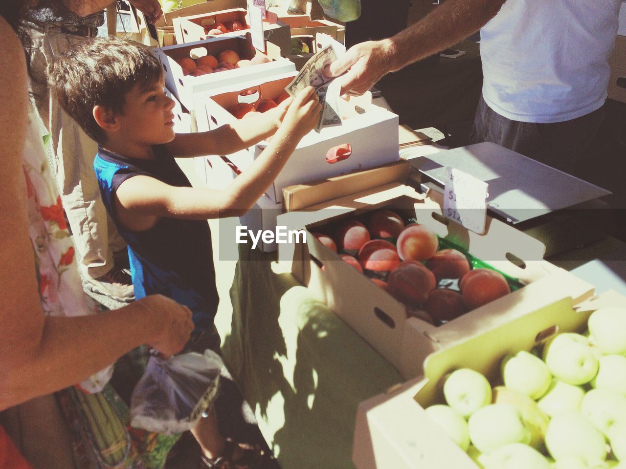 High angle view of boy buying fruit with mother in market