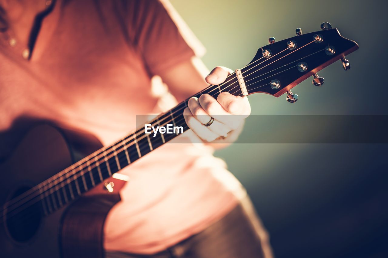 Midsection of woman playing guitar