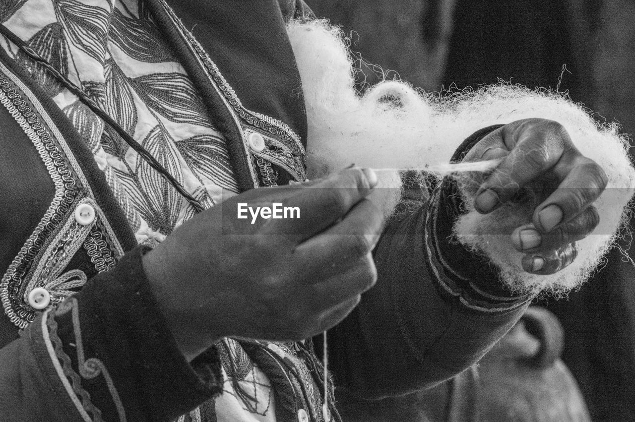 Midsection of person pulling polyester fiber