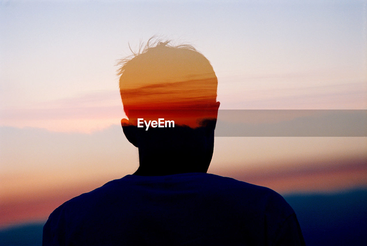 Multiple exposure of man and orange sky