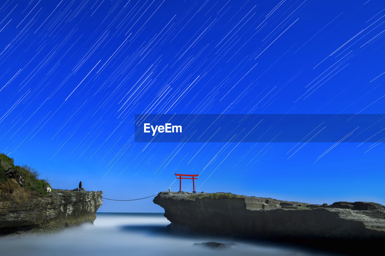 Star trails over torii gate in the sea at shirahama shrine, izu peninsula, japan