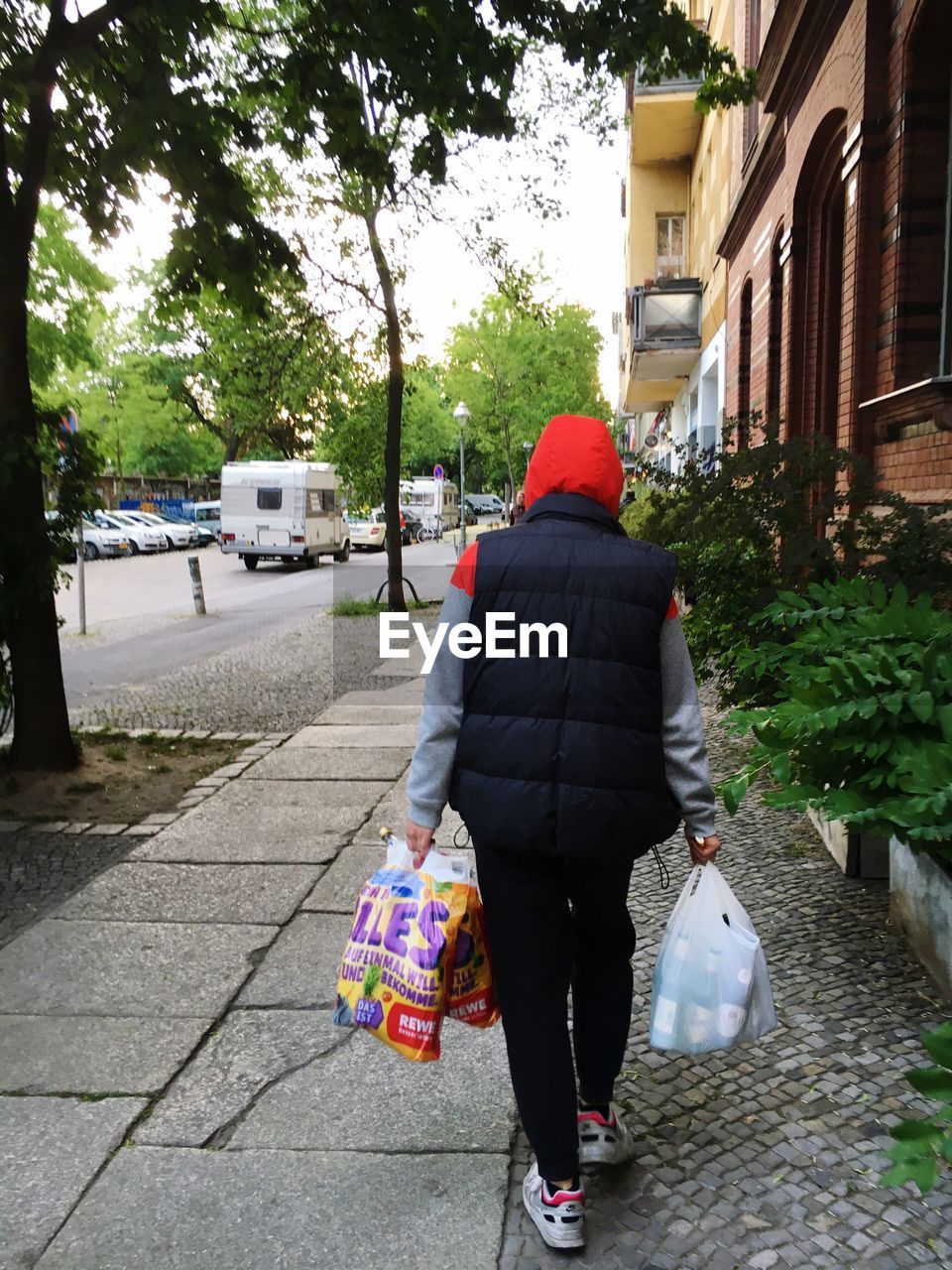 REAR VIEW OF WOMAN WALKING ON STREET