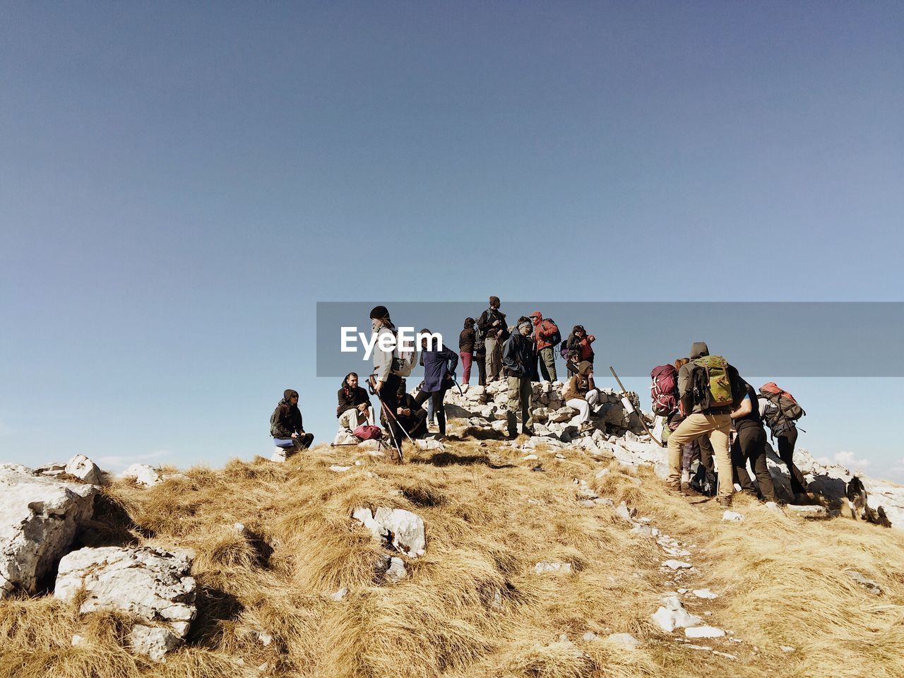 Low angle view of hikers on mountain against sky