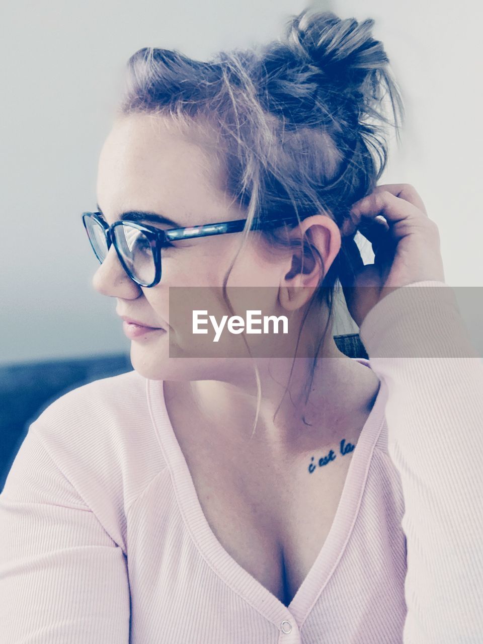 PORTRAIT OF YOUNG WOMAN WEARING EYEGLASSES AND HAT