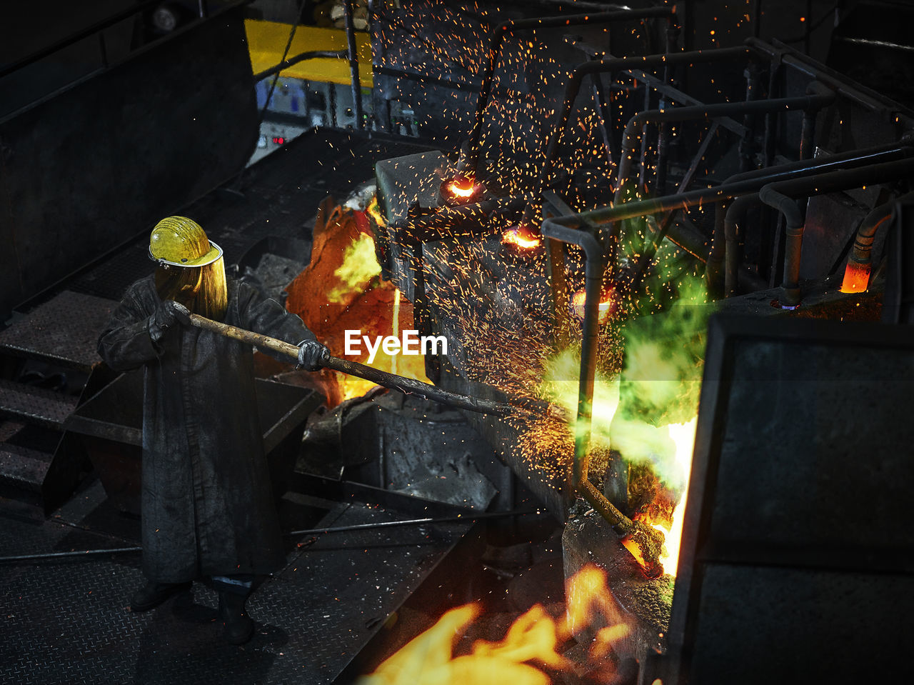 Industry, worker at furnace during melting copper, wearing a fire proximity suit