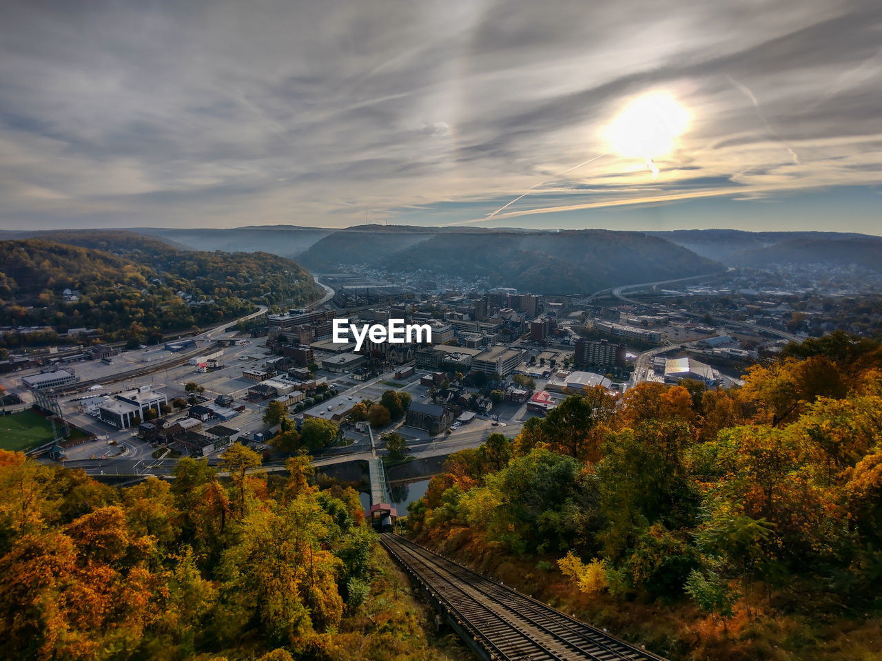 High angle view of incline tracks by city with mountains against sky