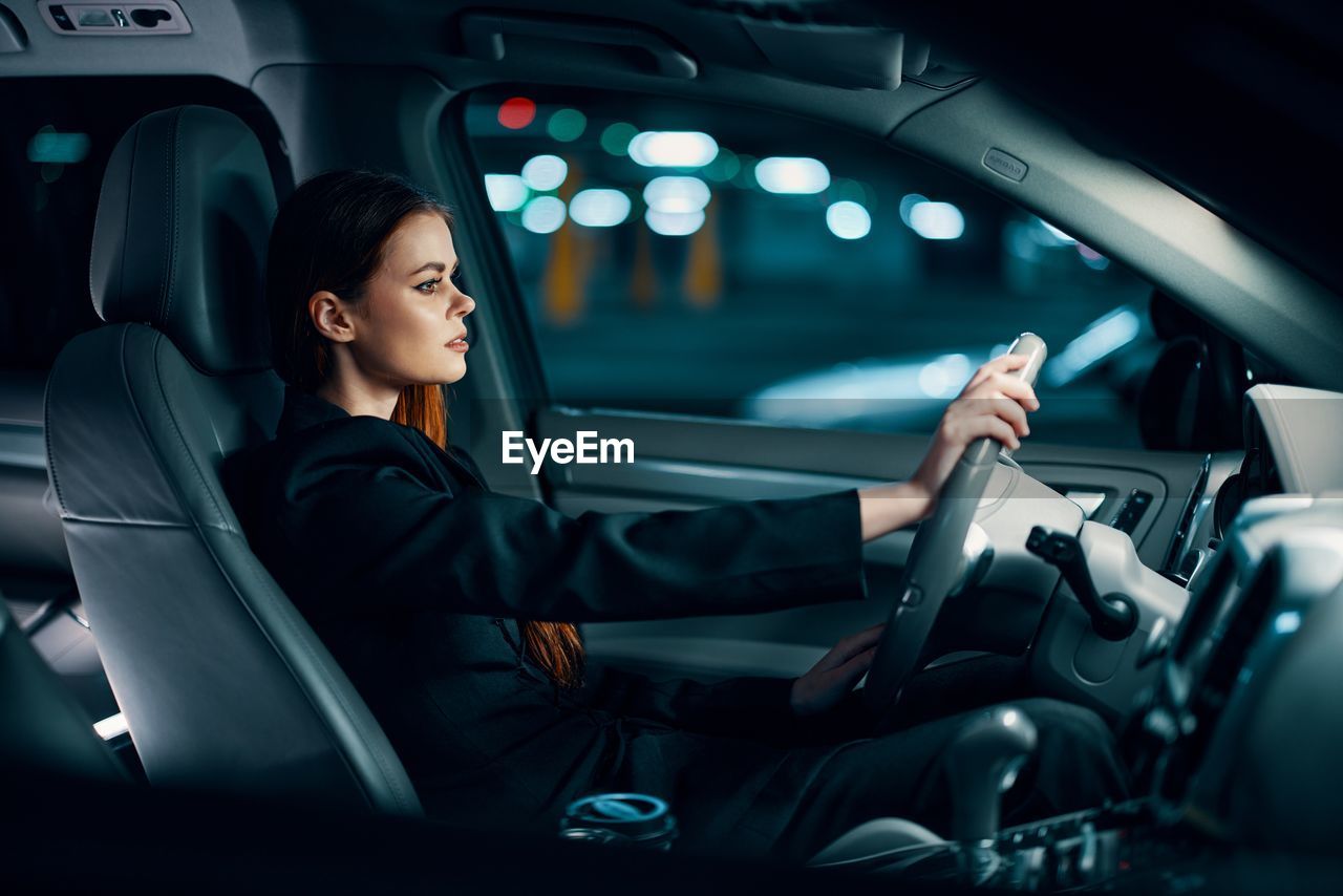 Portrait of young woman sitting in car