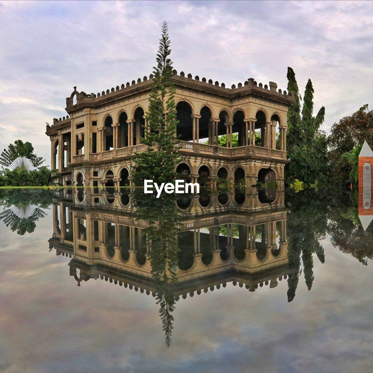 REFLECTION OF BUILDING IN LAKE AGAINST SKY