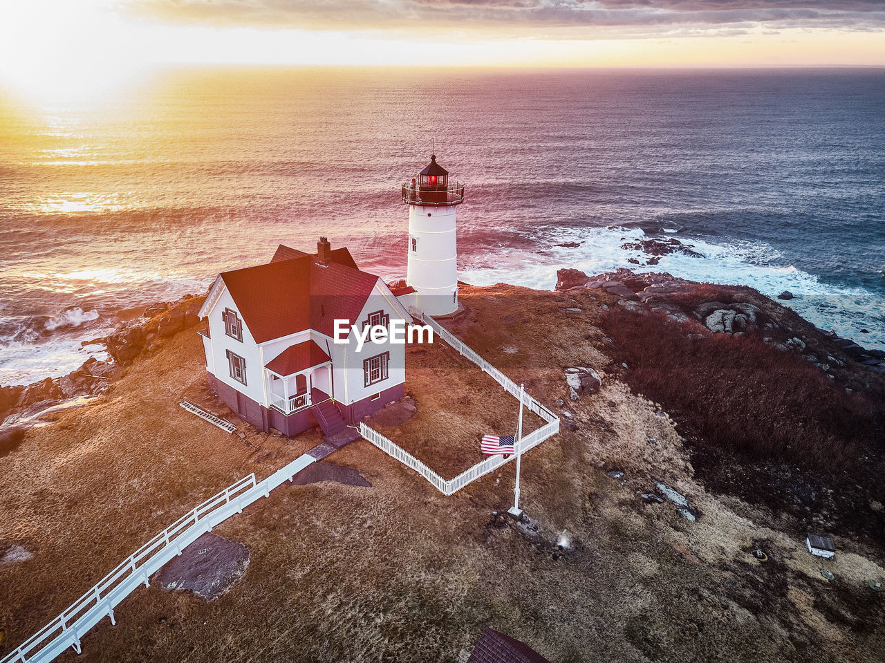 High angle view of lighthouse on beach by sea against sky