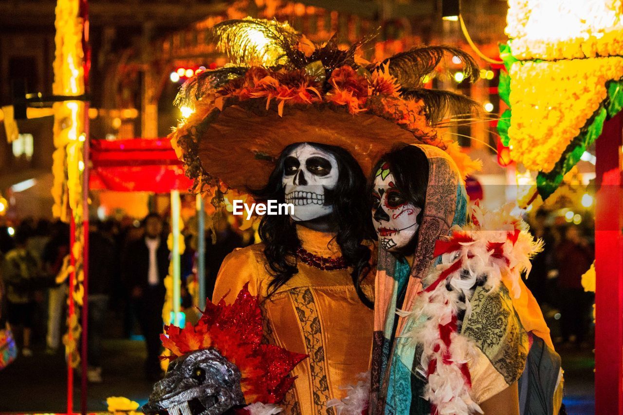 Close-up of people with spooky make-up at night during carnival