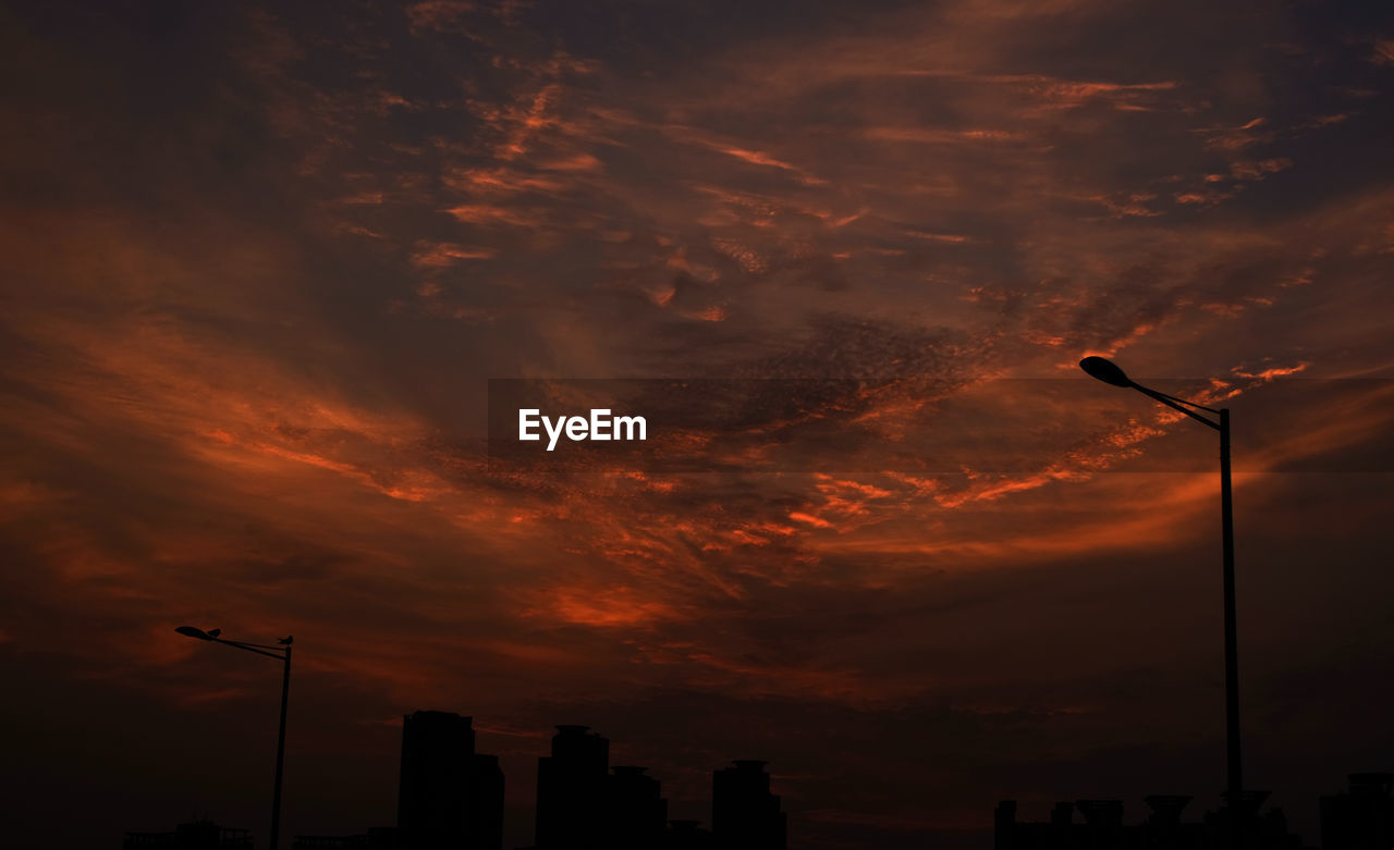 LOW ANGLE VIEW OF STREET LIGHT AGAINST DRAMATIC SKY