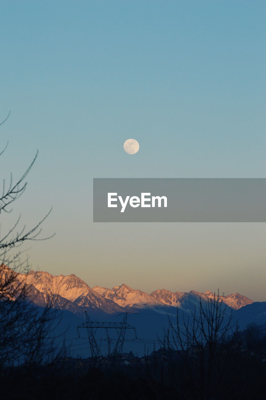 Full moon over mountain at dusk