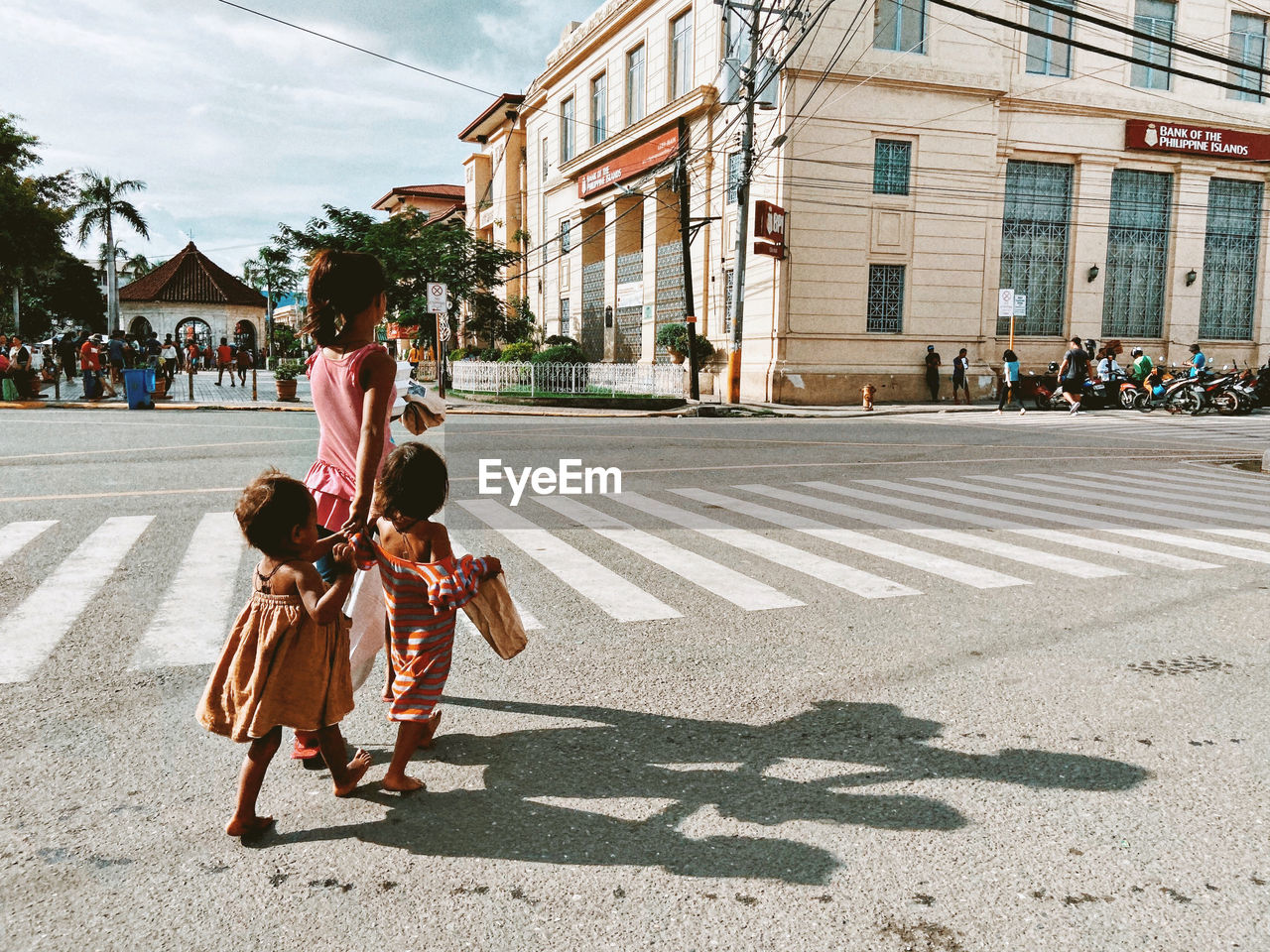 REAR VIEW OF WOMEN WALKING ON ROAD