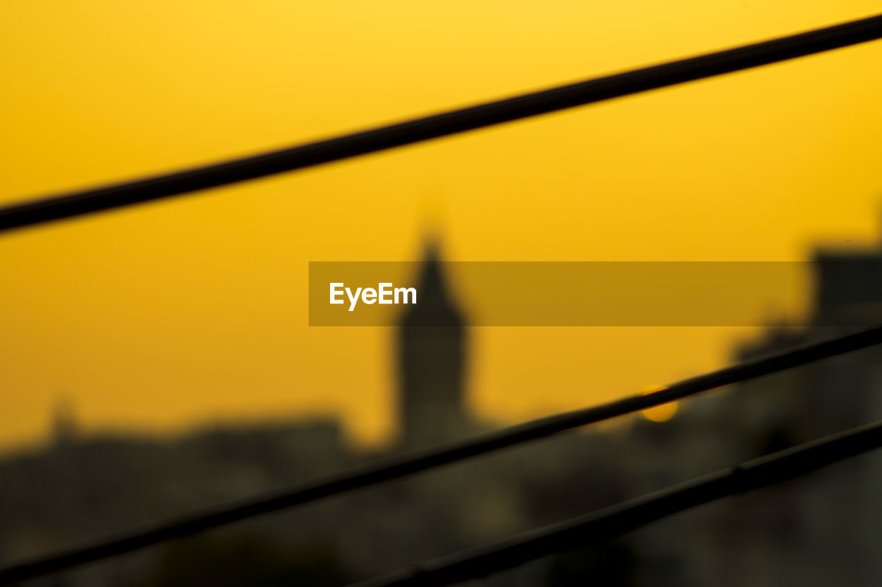 Close-up of silhouette suspension bridge against sky during sunset