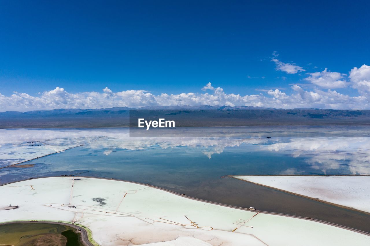 SCENIC VIEW OF LAKE BY MOUNTAINS AGAINST BLUE SKY