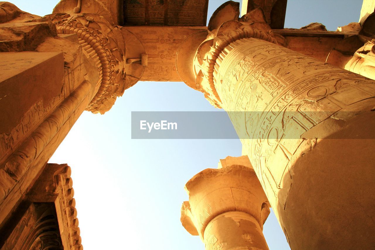 Hieroglyphics on columns against clear sky