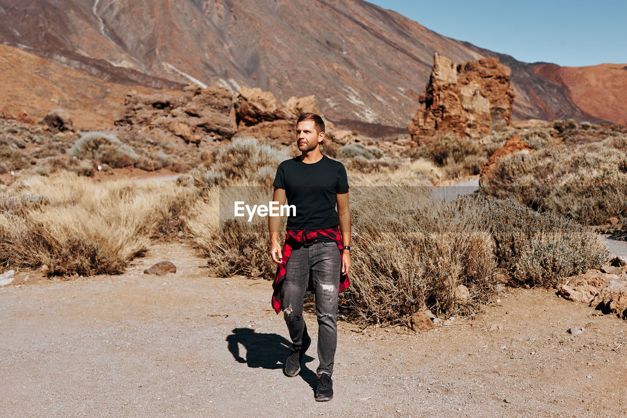 Full length of man walking on land against mountain