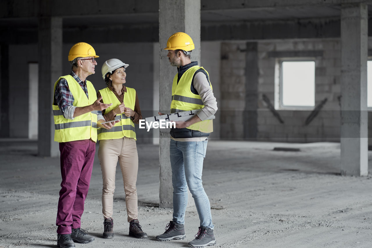 Architects discussing together at construction site