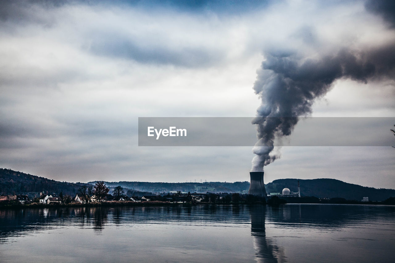 SMOKE EMITTING FROM FACTORY AGAINST CLOUDY SKY