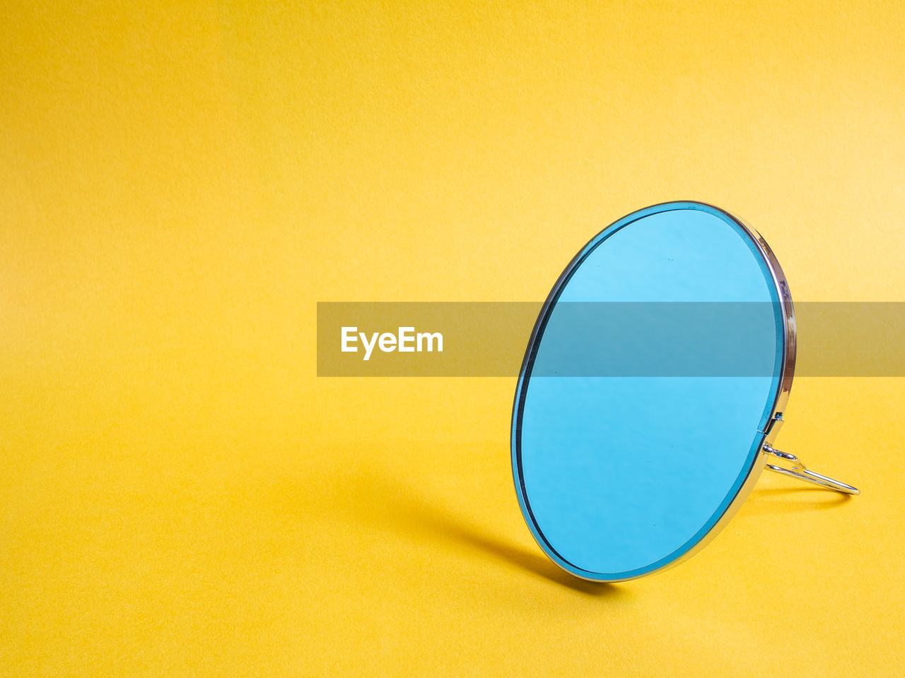 Close-up of sunglasses on table against yellow background