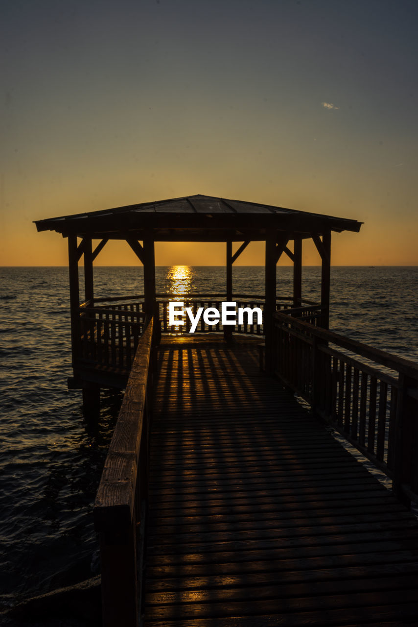PIER ON SEA AGAINST SKY AT SUNSET