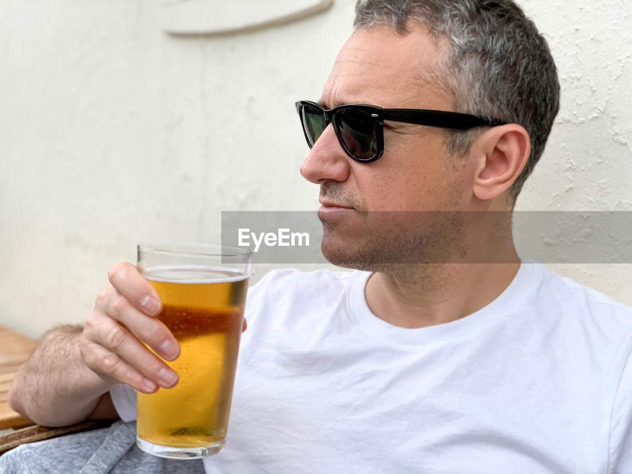 Middle aged man is drinking beer in a cafe or restaurant pub outdoor. drinking alcohol lager or ale