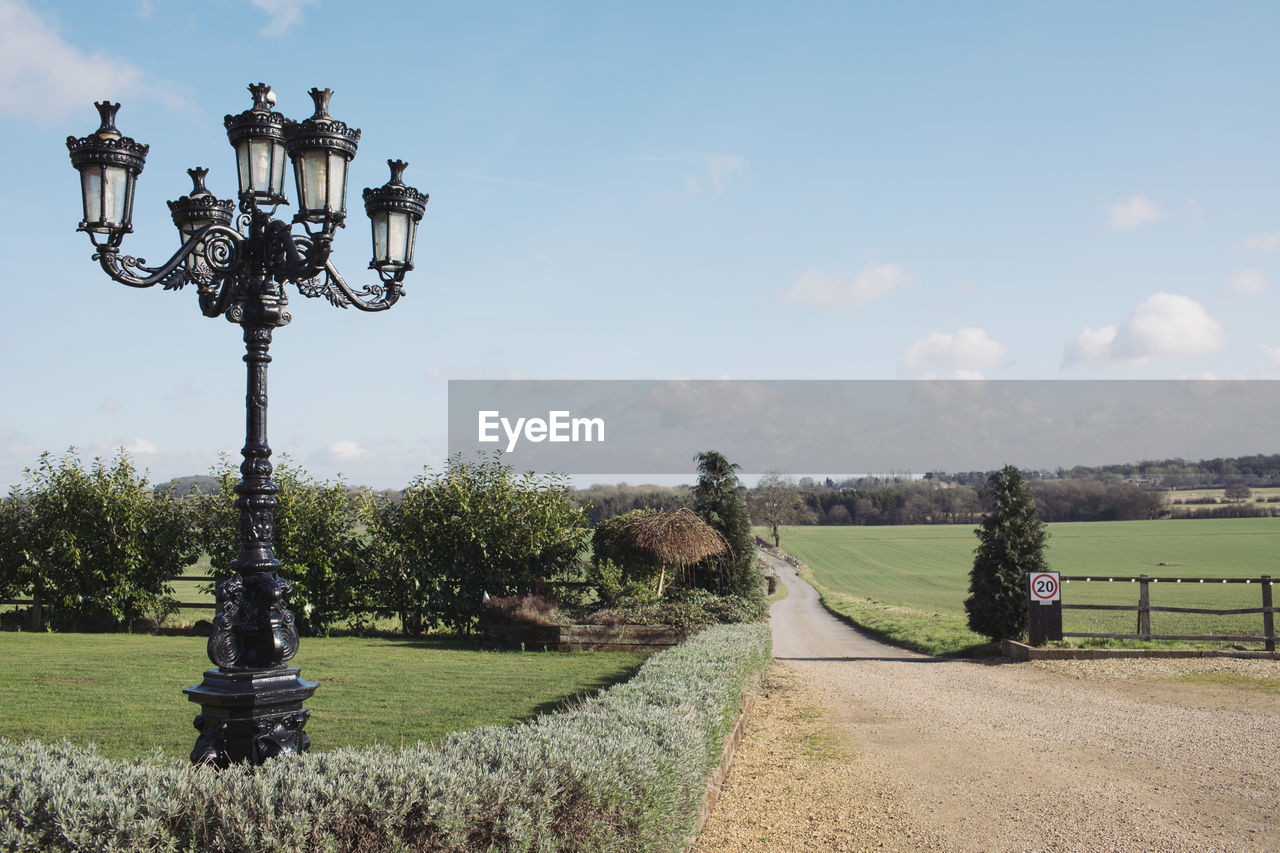 Street light by trees against sky