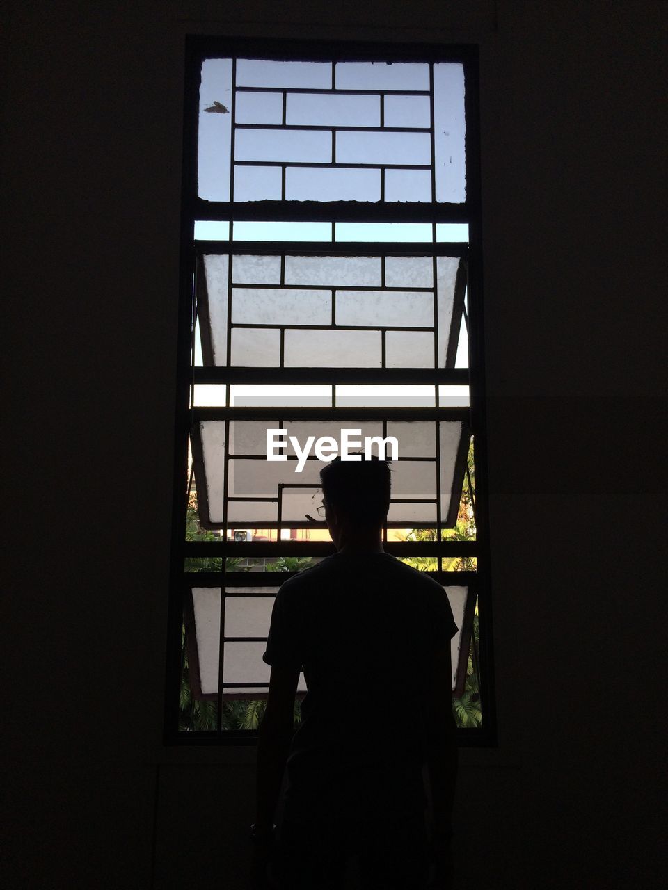 REAR VIEW OF A SILHOUETTE MAN IN WINDOW