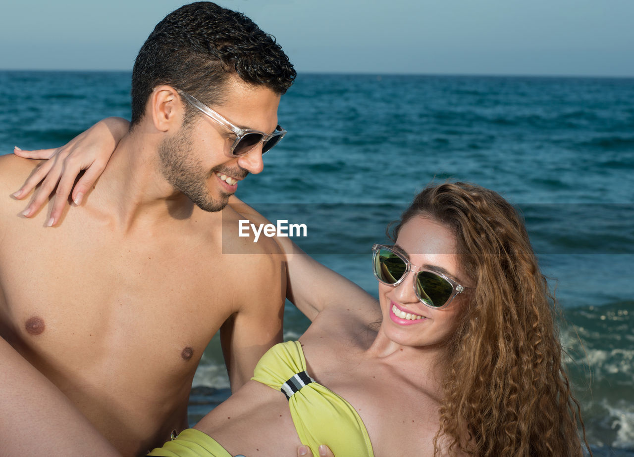 Portrait of young couple kissing in sea