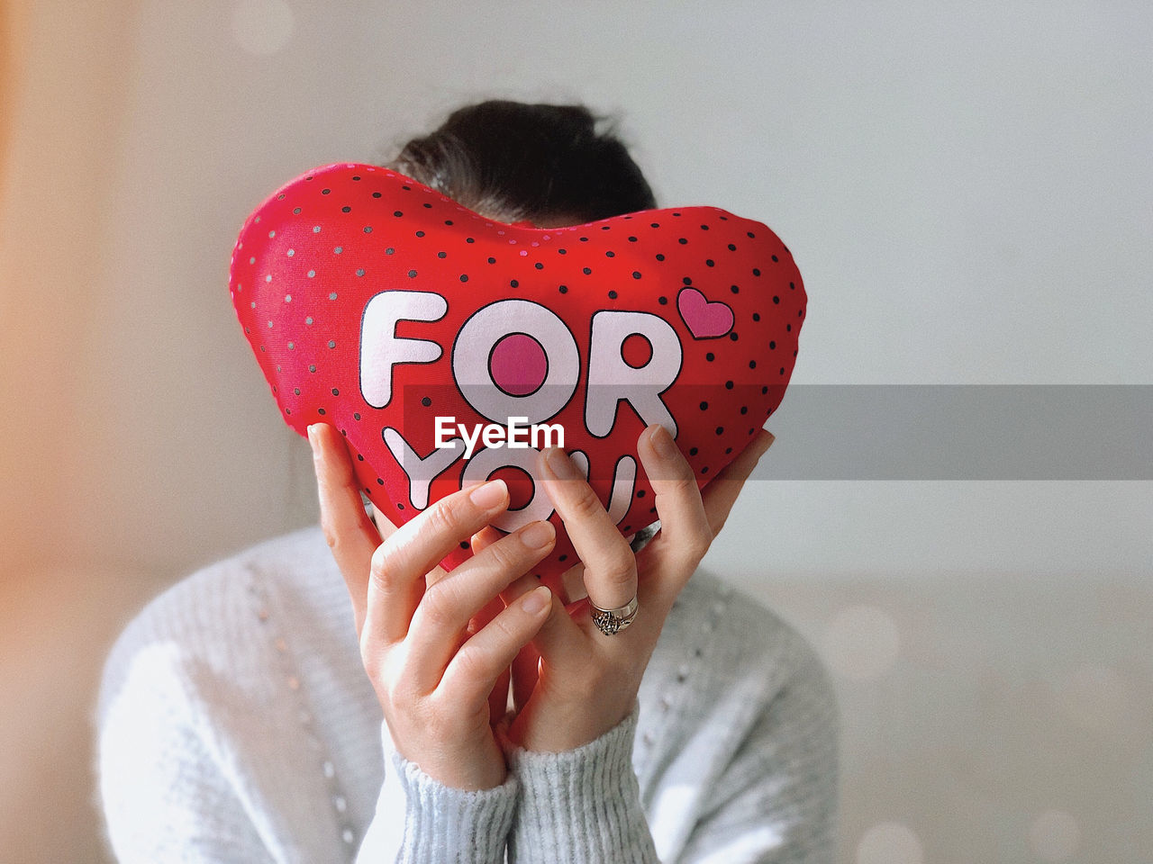 Cropped hand of woman holding heart shape at home