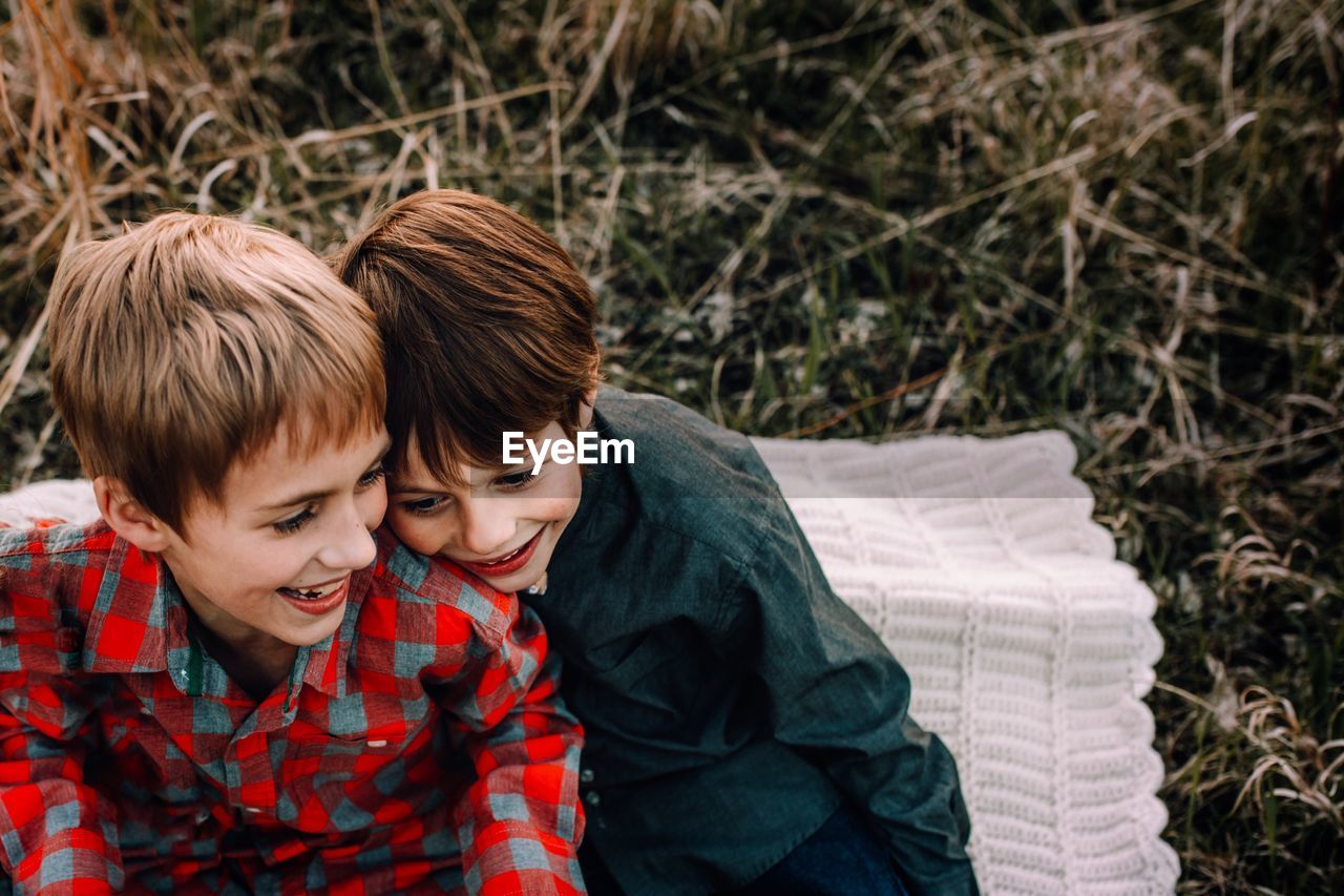 Cheerful siblings sitting in park