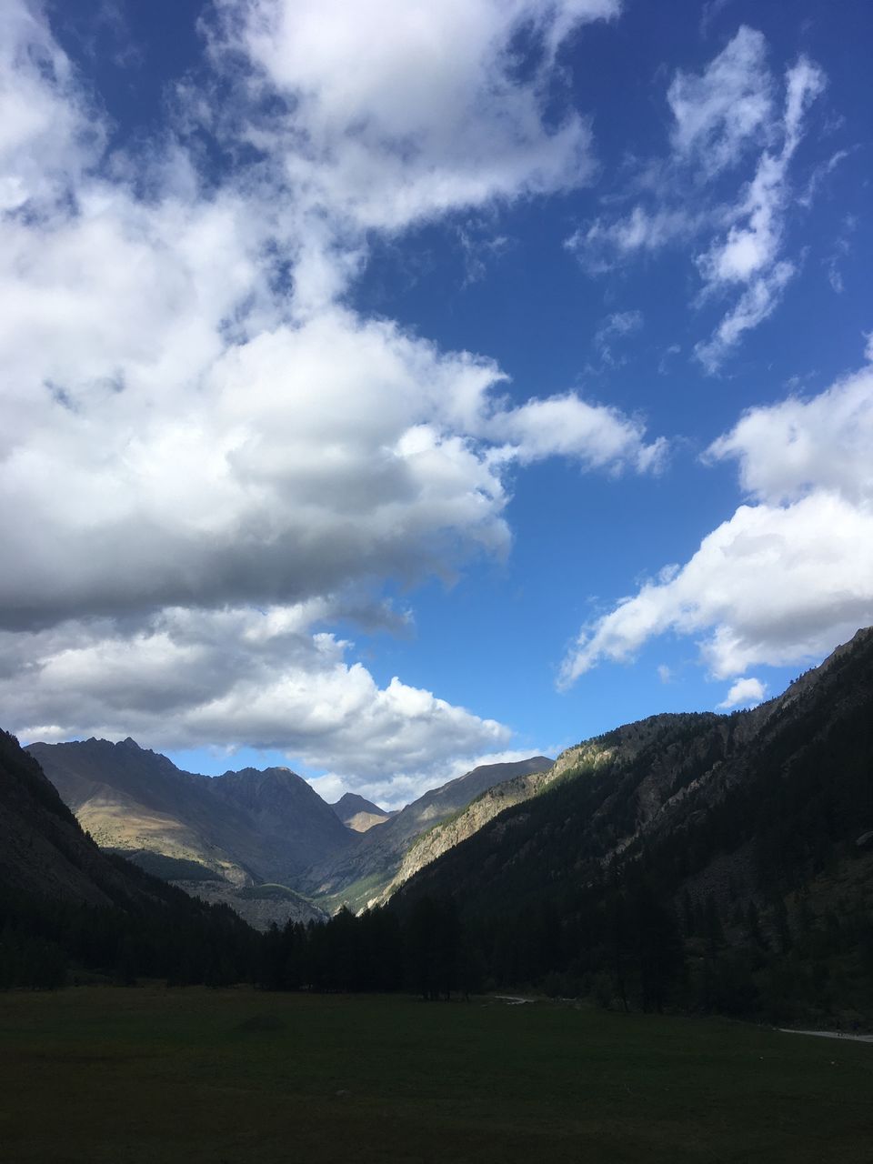 SCENIC VIEW OF LANDSCAPE AND MOUNTAINS AGAINST CLOUDY SKY