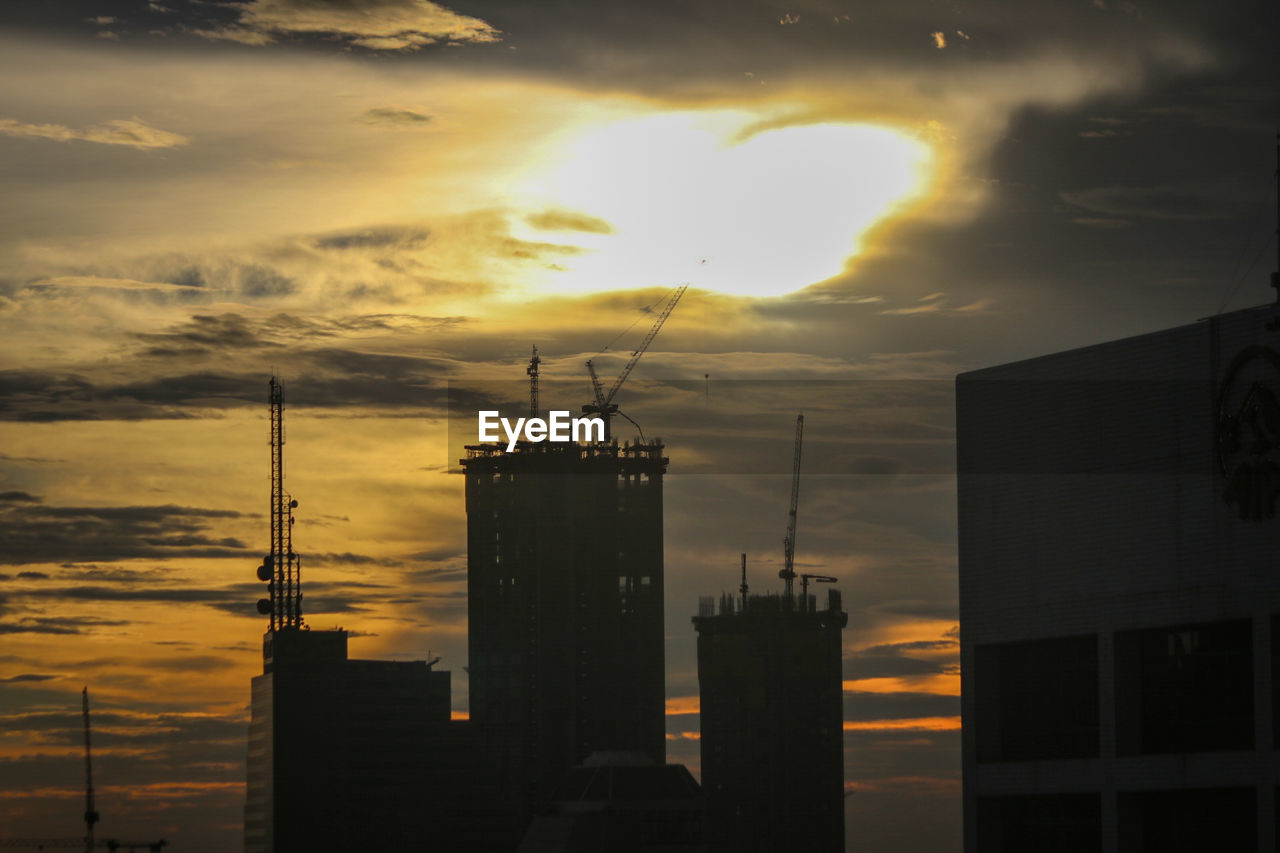 SILHOUETTE OF BUILDINGS AGAINST SKY DURING SUNSET