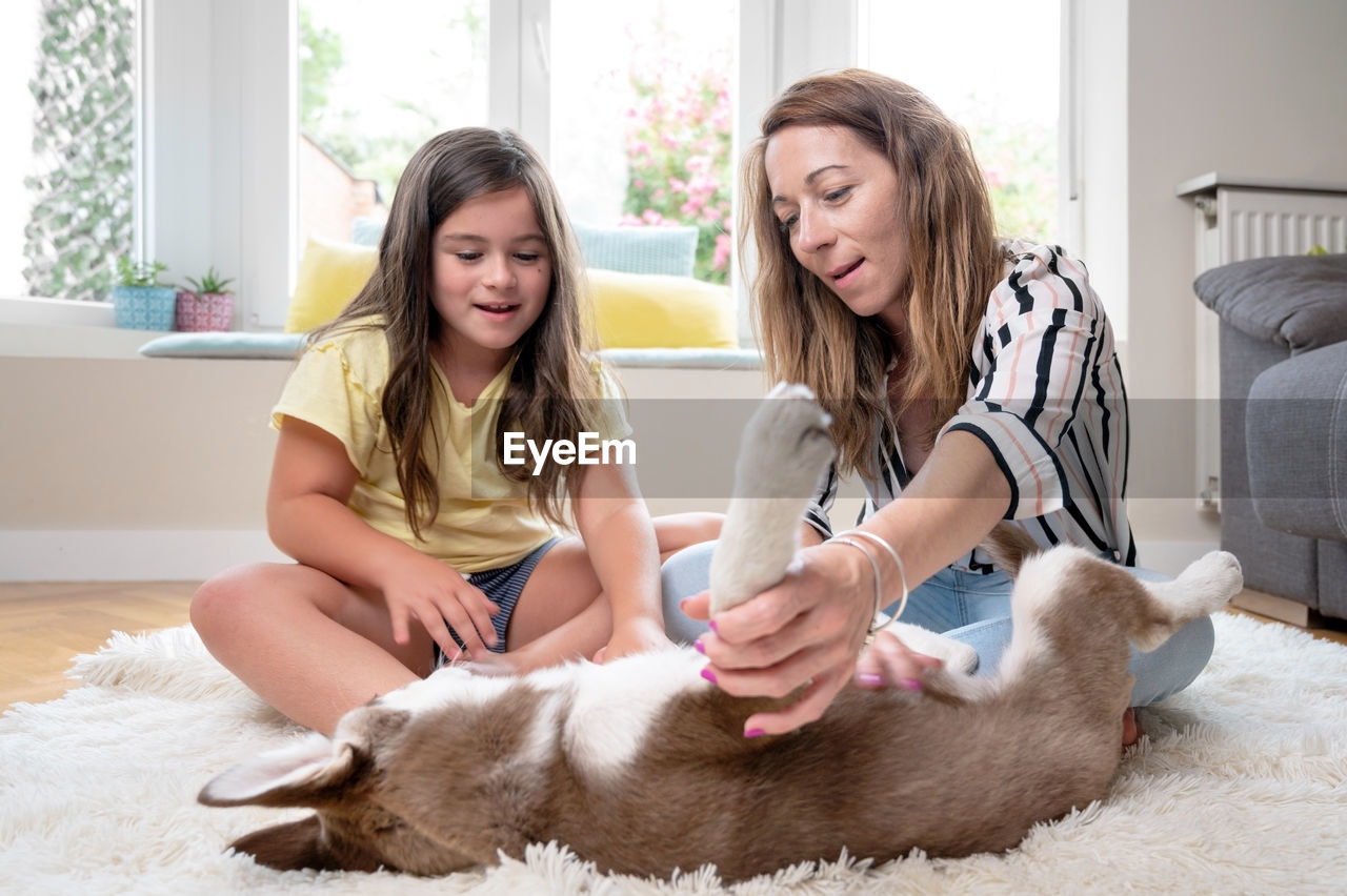 portrait of smiling young woman with dog at home