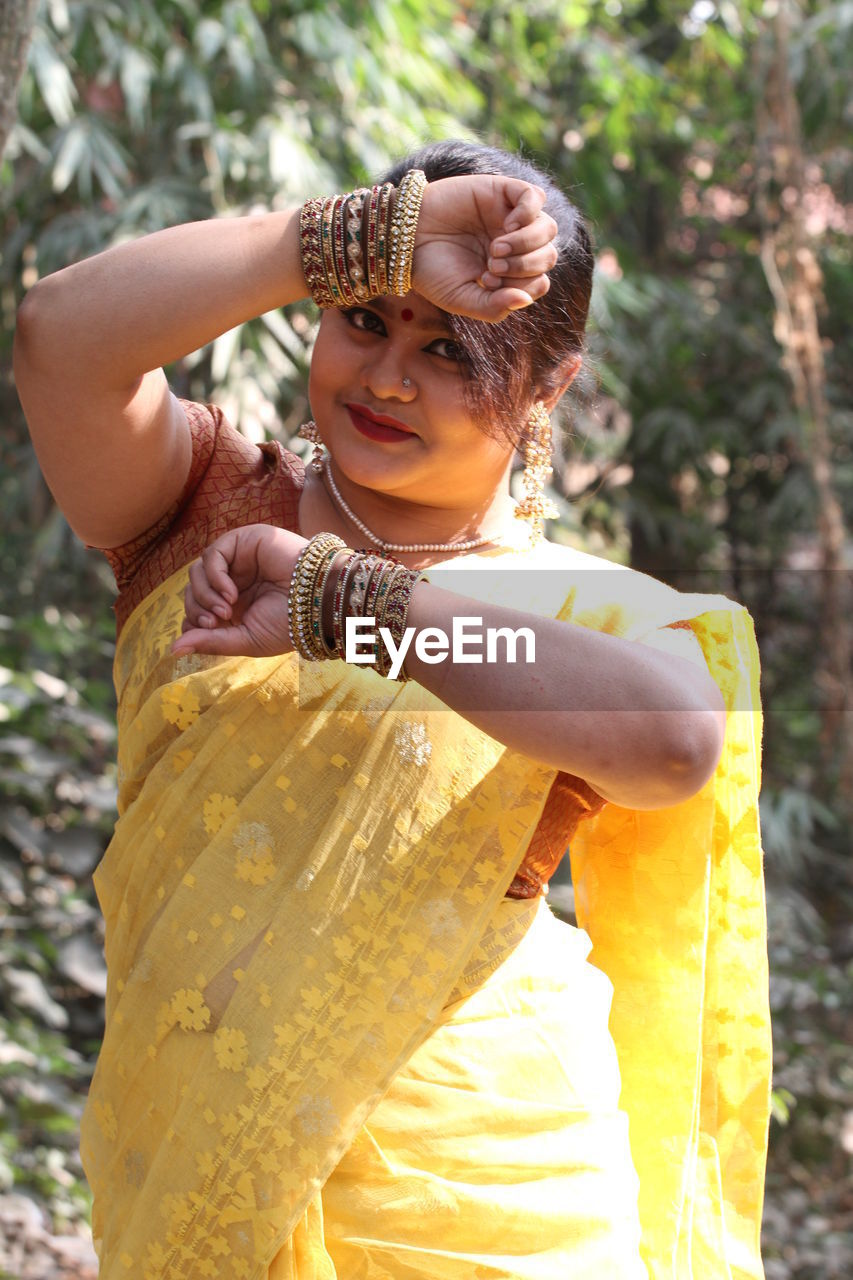 Portrait of smiling beautiful woman wearing yellow sari