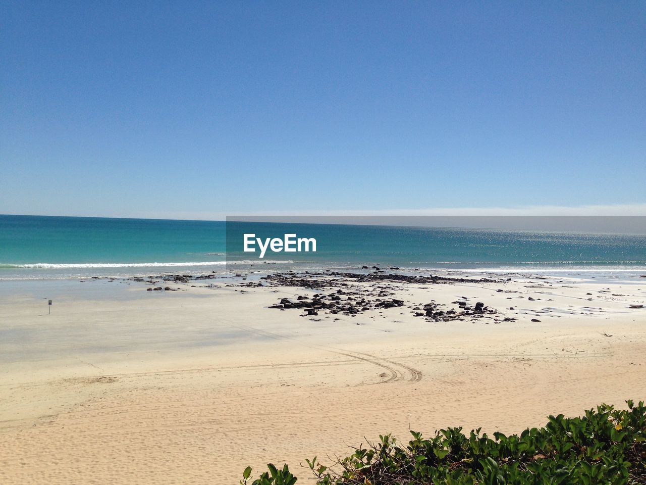 SCENIC VIEW OF BEACH AGAINST BLUE SKY