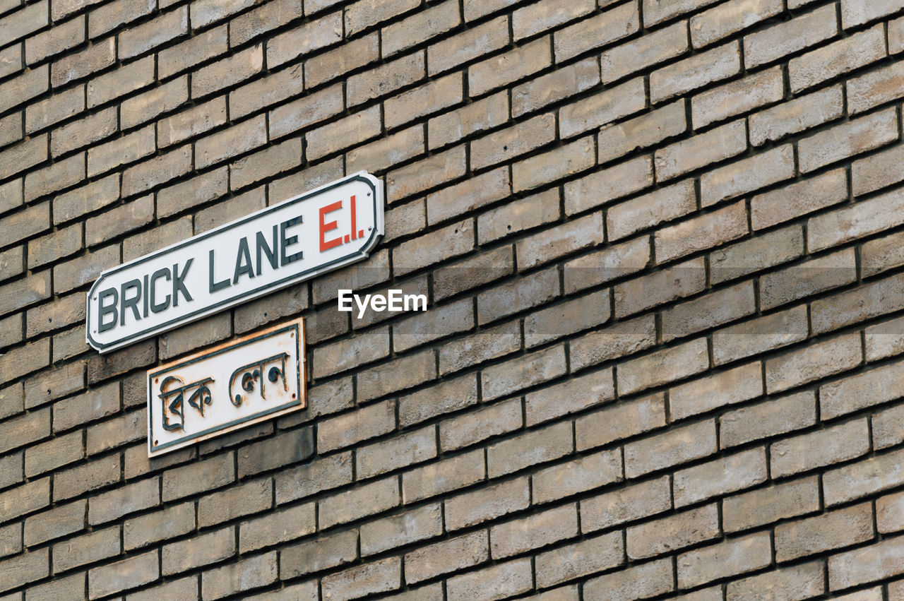 Low angle view of information sign on brick wall