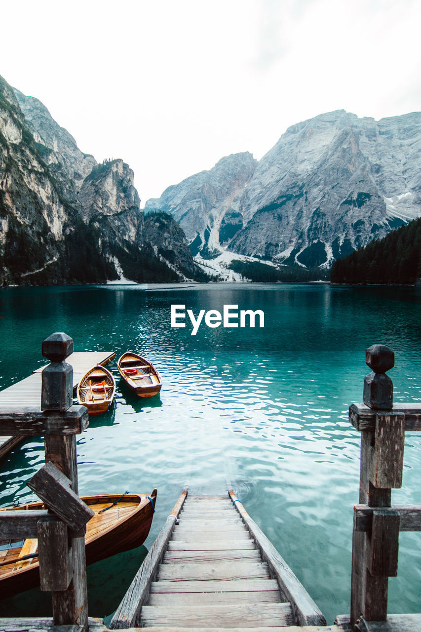 From above wooden quay on amazing scenery of lake with turquoise water in mountains on foggy day