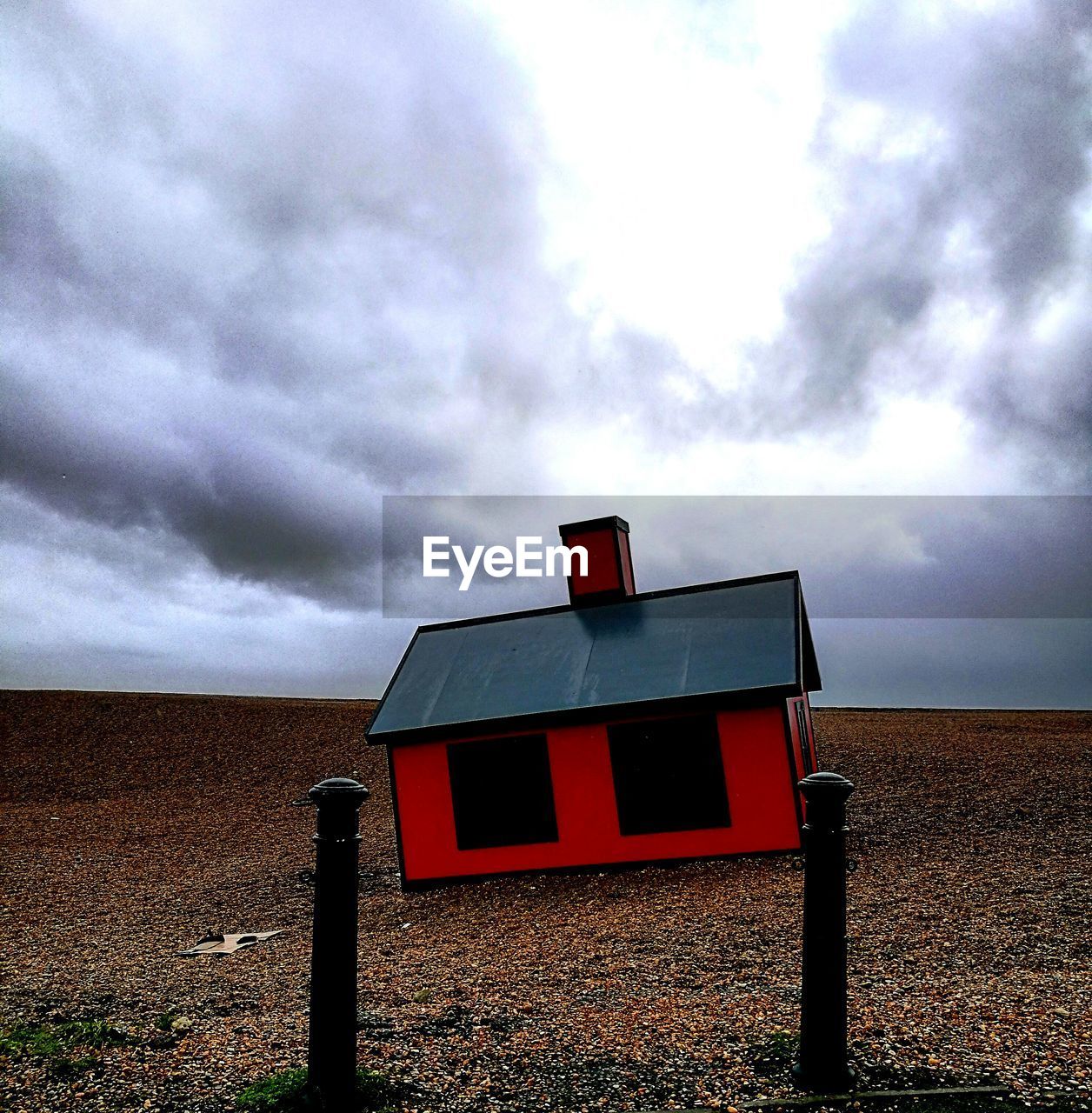 VIEW OF BUILDING ON FIELD AGAINST SKY