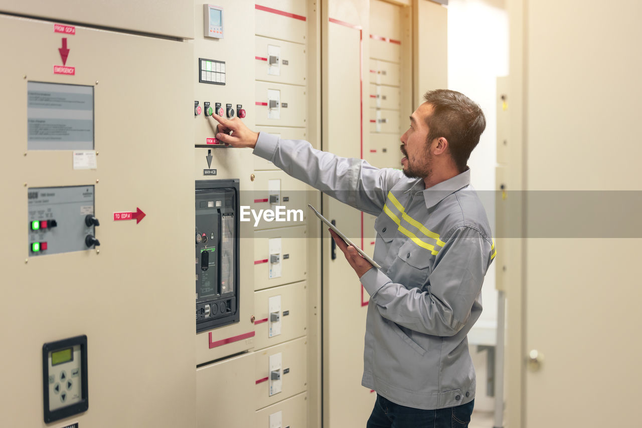 Close up hand of engineer or electrician man working check the electrical system with tablet