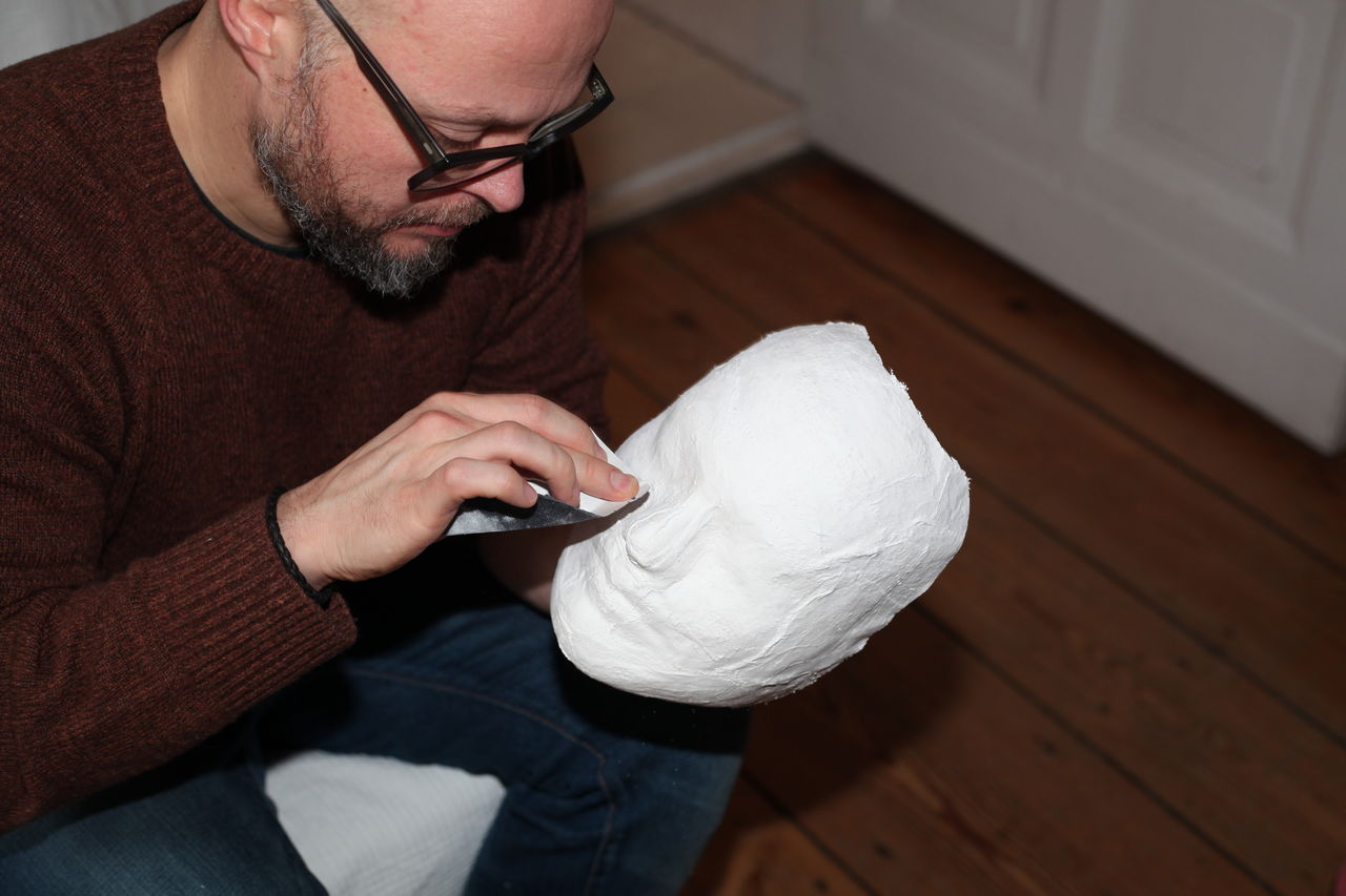 High angle view of man holding mask at home