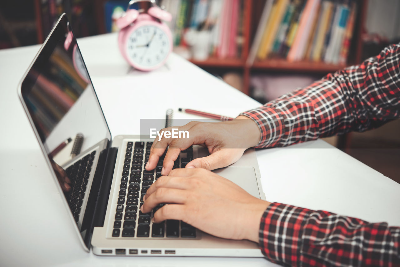 MAN USING LAPTOP ON TABLE