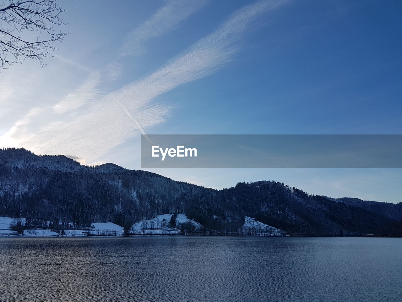 Scenic view of lake by mountains against sky